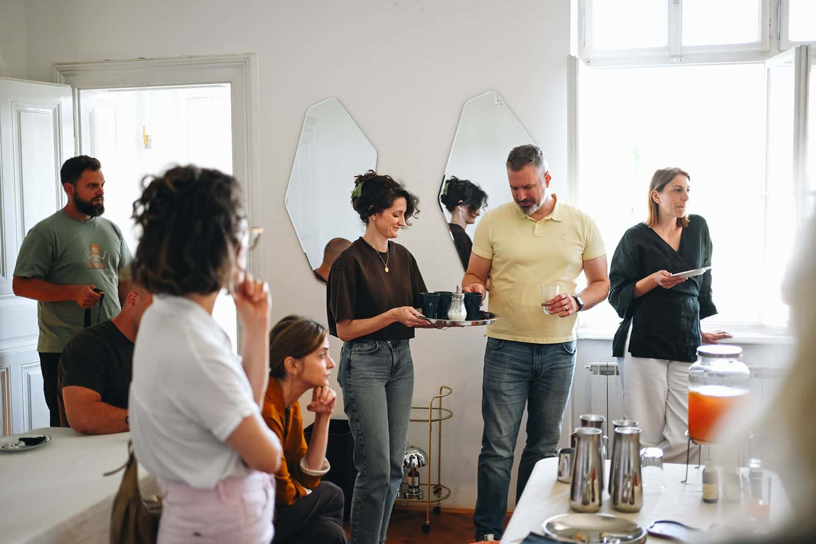 Participants stand by the coffee table and talk before the workshop starts