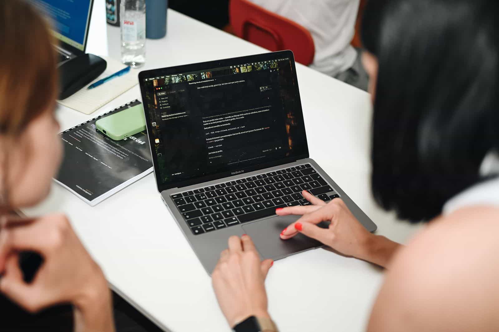Hands on a laptop keyboard as code scrolls on screen