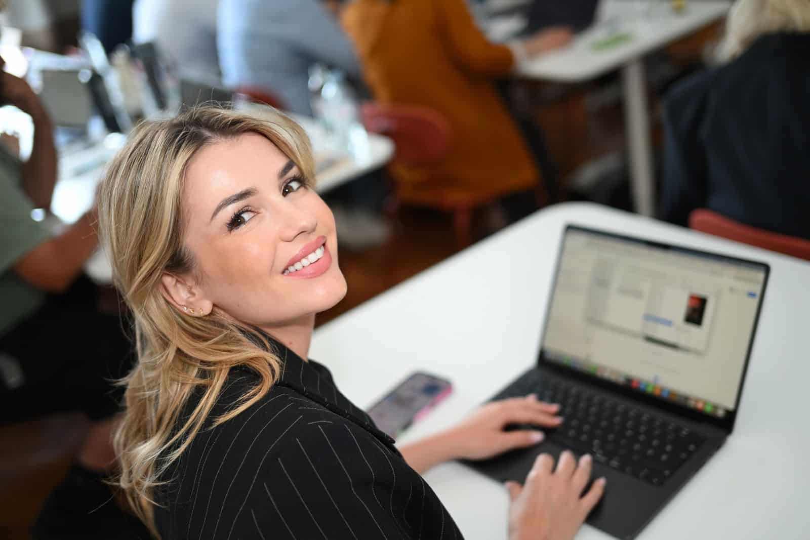 Astrid Čada works at a laptop and glances towards the camera