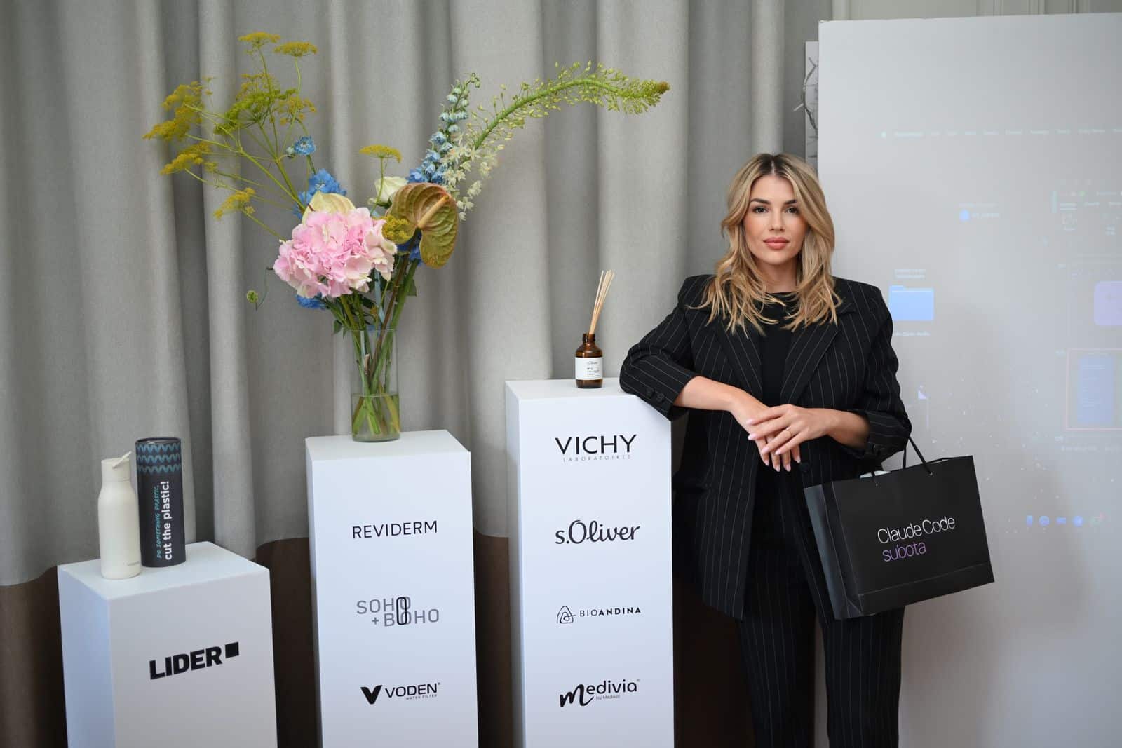 Astrid Čada in front of the projection wall and the partner plinths
