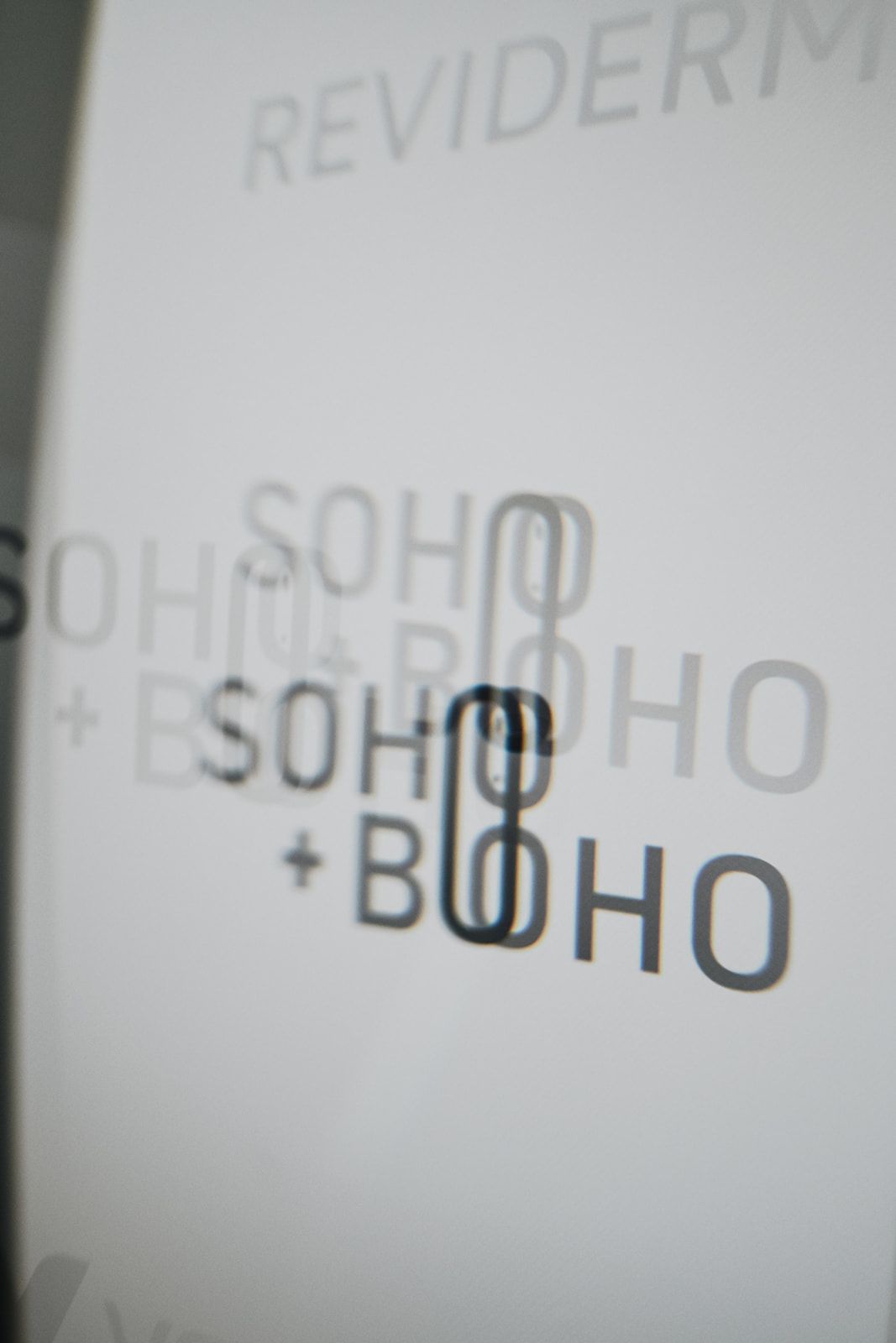 Detail of the SOHO plus BOHO logo on a glass surface