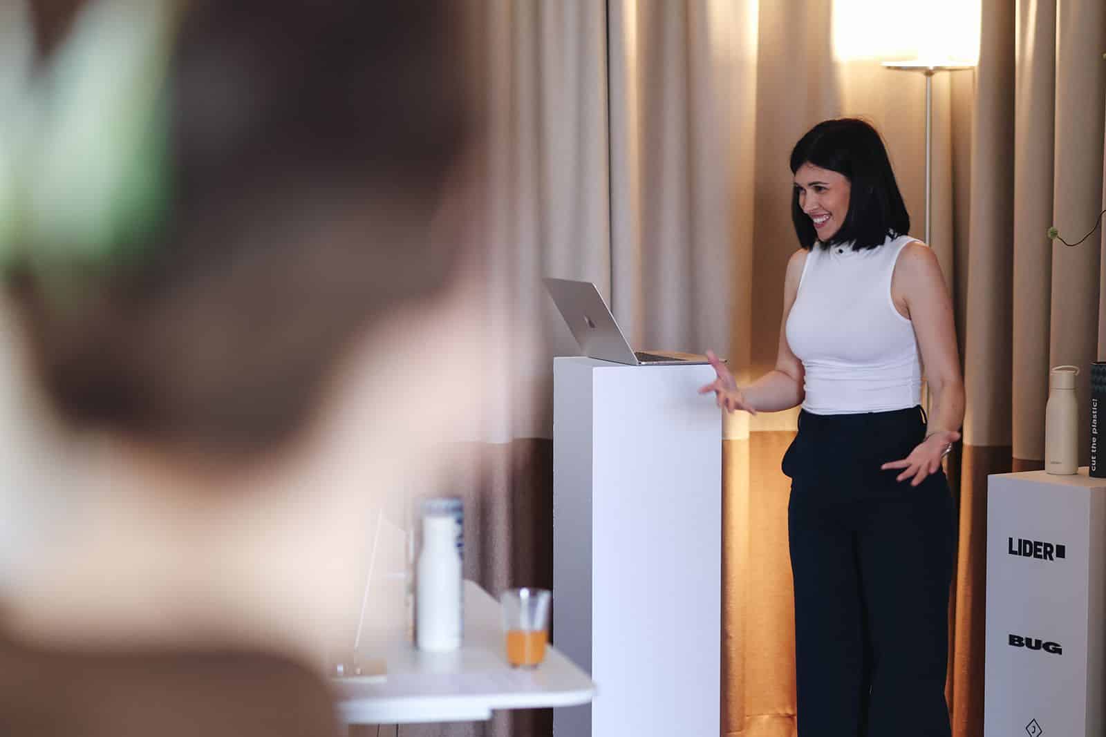 Patricija Topić gives the opening talk beside a laptop on a plinth