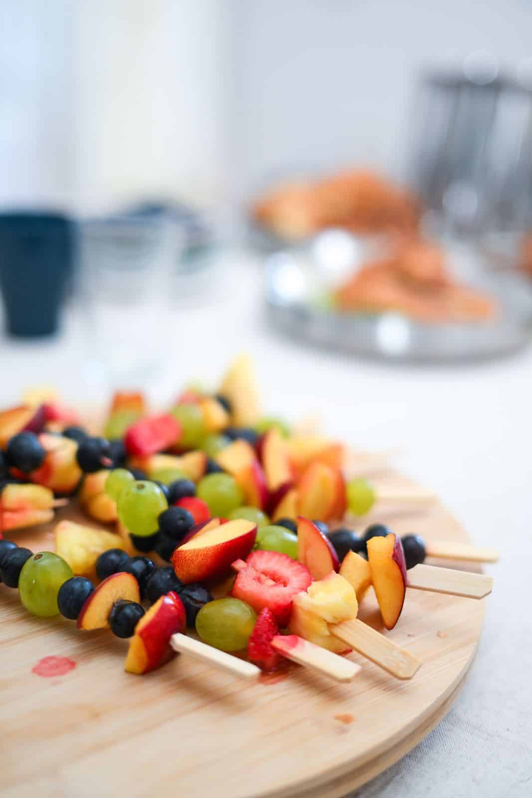 Fruit skewers arranged on a wooden board