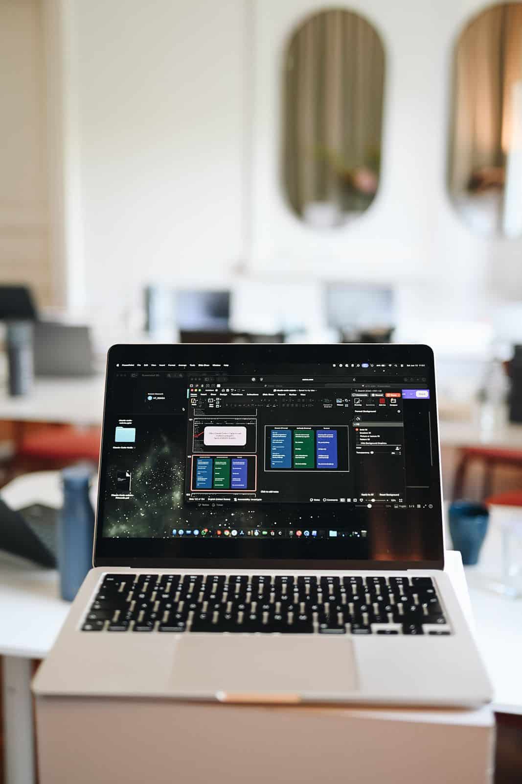 A MacBook with the Claude Code interface open on a working table