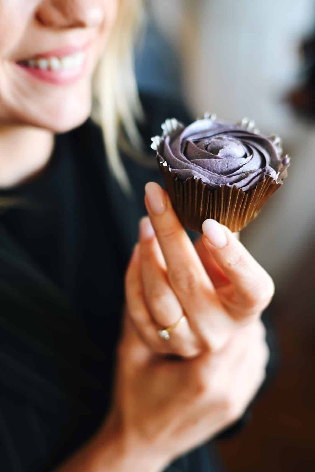 A participant holds a purple cupcake