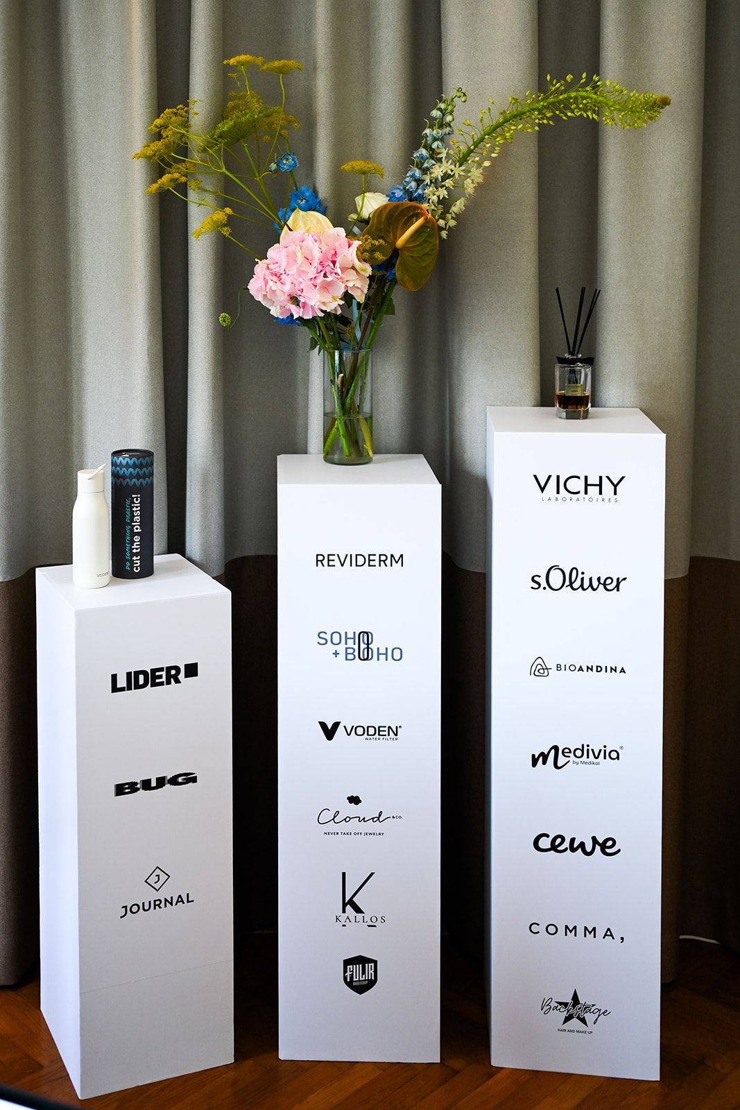 White plinths with the logos of the workshop partners