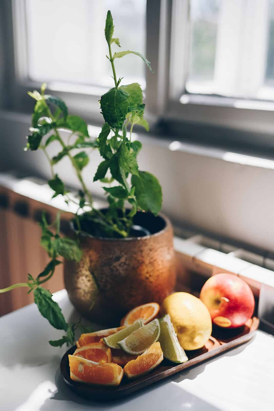 Fruit and a plant on the window ledge lit by morning light