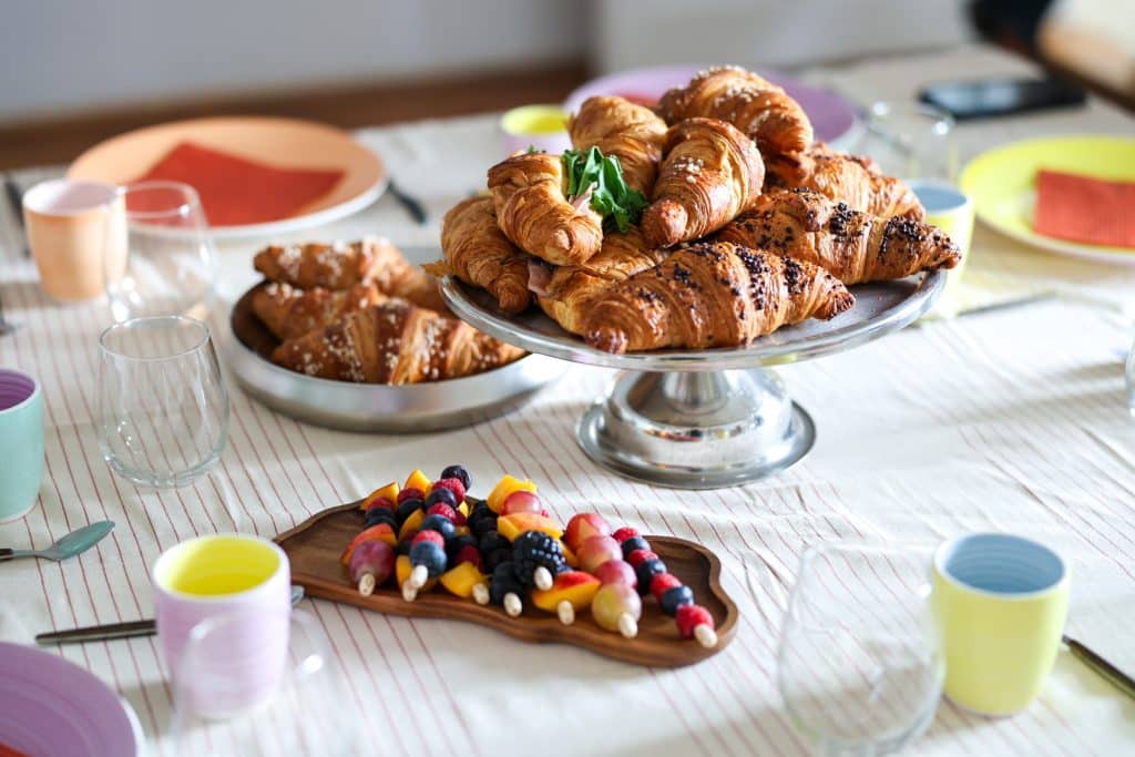 Breakfast with croissants and fruit on the table before Claude Code Saturday begins